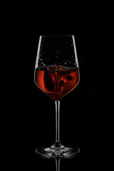 Red wine in a glass goblet on a black background