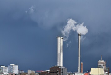 Rauchende Schornsteine – Kraftwerk Mitte vor dunkelblauer Wetterwolke