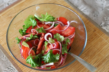 summer salad. tomatoes, green vegetables, red onions.