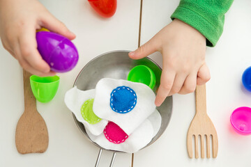 Happy Easter theme. Kid sorting eggs and learning colors. Montessori format task for kids education. Preschool toy for fine motor skils and training of imagination.