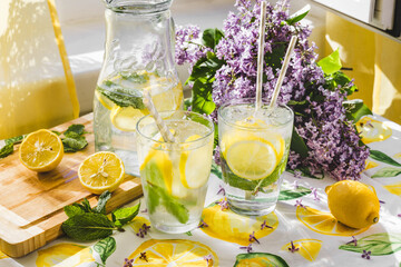 Summer scene of lemonade next to a window. Sunlight comes from the window. Lilac flowers on the background - obrazy, fototapety, plakaty