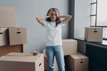 Exhausted woman is tired from packing cardboard boxes with duct tape. Anxiety and stress.