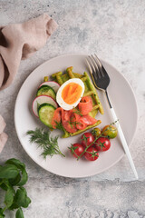 Savory waffles. Breakfast green waffles wild garlic or spinach with egg, tomato, salmon on plate for breakfast on grey concrete table background. Light dinner, lunch or breakfast. Top view. Mock up.