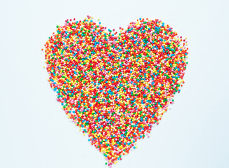 Colored sugar balls on a white background in the form of a heart. Used to decorate pastries and sweets.