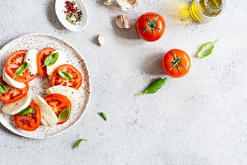 Caprese salad with juicy tomatoes, fresh mozzarella and pesto. Concept for a tasty and healthy appetizer, flat lay. Italian food, cuisine.