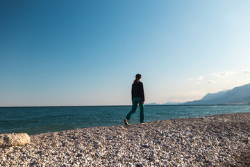 A girl walks along the beach alone