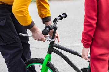 Fototapeta na wymiar Father and son fixing a bike with wrench
