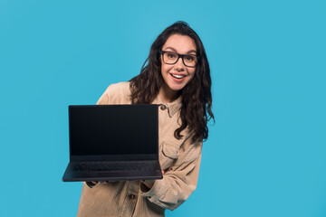 Glad surprised funny young european lady student in glasses shows laptop with blank screen