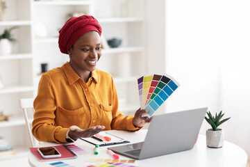 Cheerful african american muslim lady designer having video conference