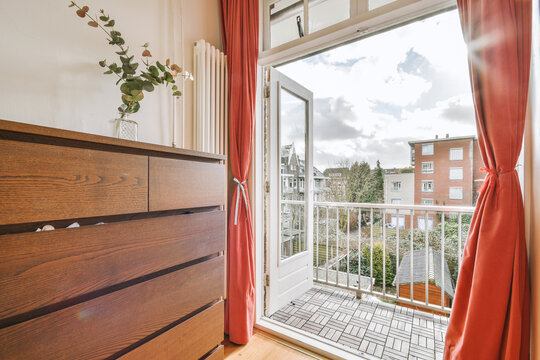 Chest of drawers and glass door of balcony with fence