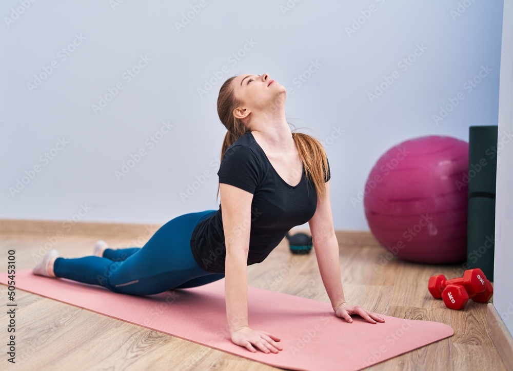 Sticker Young blonde woman stretching at sport center