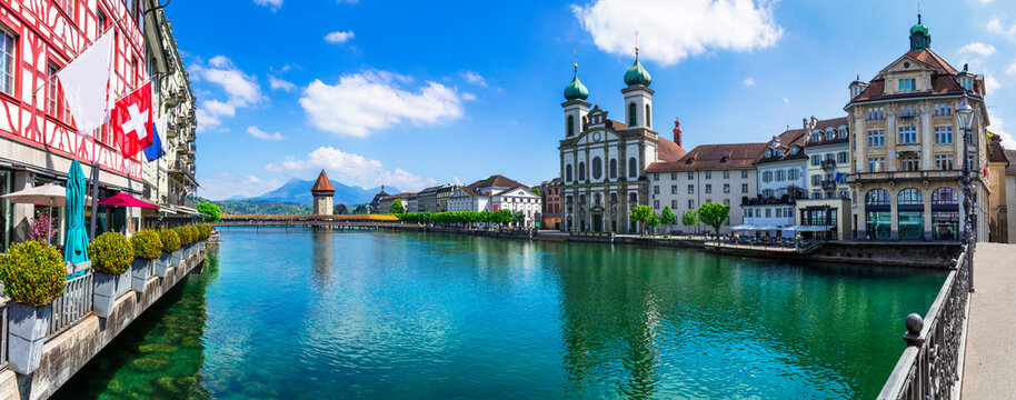 Panoramic view of Lucerne (Luzern) town with famous Chapel wooden bridge over Reuss river and Jesuit Church.  Switzerland travel and landmarks.
