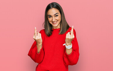 Beautiful brunette woman wearing casual winter sweater showing middle finger doing fuck you bad expression, provocation and rude attitude. screaming excited