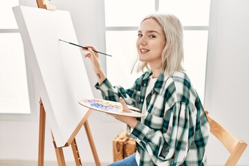 Young artist student girl smiling happy painting at art studio.