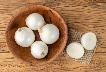 White onions in a bowl over wooden table