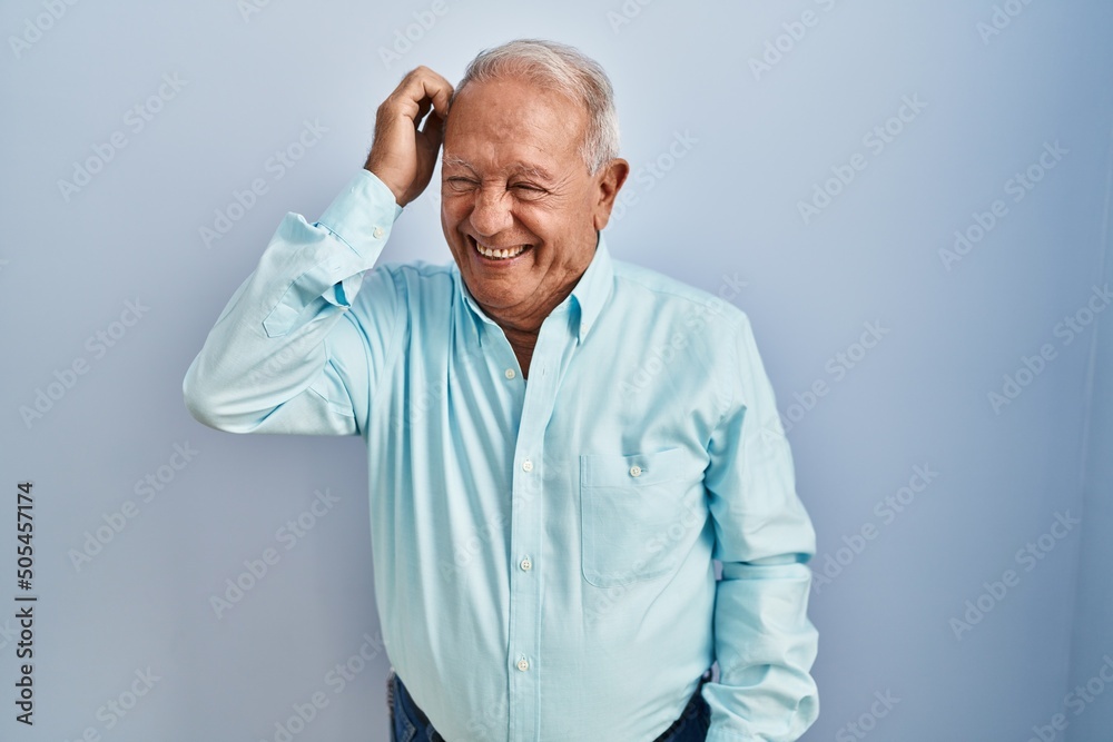 Poster senior man with grey hair standing over blue background confuse and wonder about question. uncertain