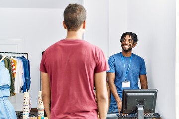 Fototapeta premium Two men shopkeeper and customer standing at clothing store