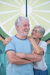 Lovely senior couple hugging smiling standing in outdoors. Youthful couple enjoying retirement