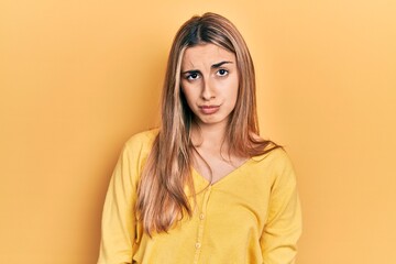 Beautiful hispanic woman wearing casual yellow sweater skeptic and nervous, frowning upset because of problem. negative person.