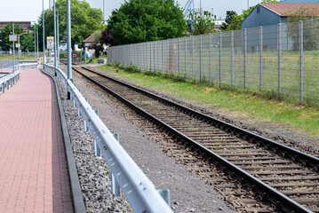 Railroad tracks lying on wooden sleepers, the tracks are arranged along the pavement and secured...