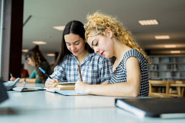 Two college students studying together in a library