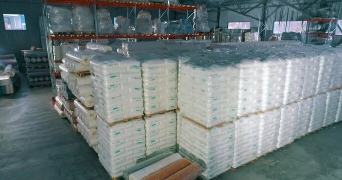 Warehouse of raw materials at the factory. Lots of raw material bag for production. Spunbond in rolls in the warehouse of the factory