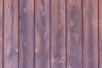 Wall of wooden brown older planks vertically.