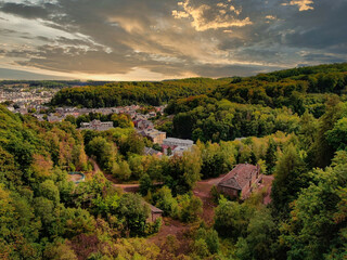 Houses surrounded by dense trees under a cloudy sky