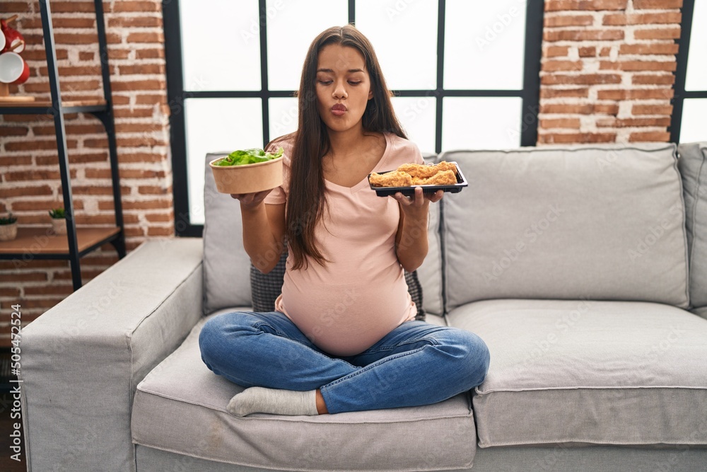 Sticker young pregnant woman craving for food at home making fish face with mouth and squinting eyes, crazy 