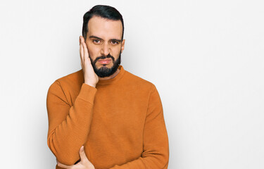 Fototapeta premium Young man with beard wearing casual winter sweater thinking looking tired and bored with depression problems with crossed arms.