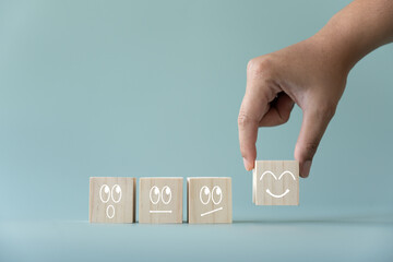Concept of customer satisfaction review. Wooden blocks with facial expression and the 