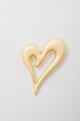 Metallic golden brooch in shape of heart, pin on white background, bijouterie, jewelry close up