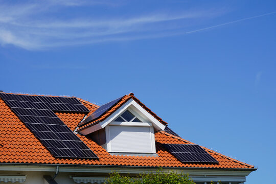 Luxurious country house with a large dormer window. New solar modules have been installed on the light bricks. 