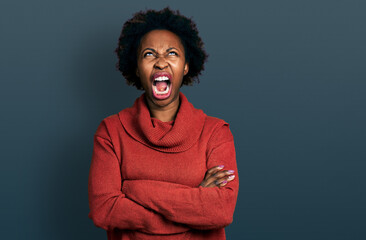 Fototapeta na wymiar African american woman with afro hair with arms crossed gesture angry and mad screaming frustrated and furious, shouting with anger looking up.