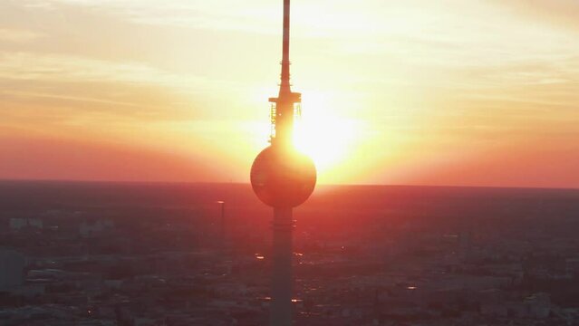 Circling the silhouette of Alexander Platz TV Tower in Berlin, Germany during sunset