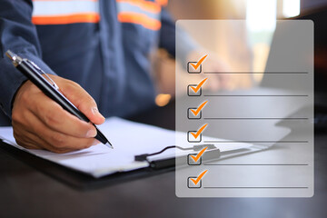An industrial or shipping inspector auditor supervisor in a reflective jacket is writing a pen on a...