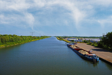 Echt, Netherlands - May 15. 2022: View from bridge on straight  maas inland waterway canal with...