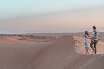 Fototapeta na wymiar Couple in love wandering around in the desert of Oman.