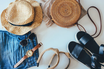 Women's summer clothes collage on white, flat lay. Woven sandals, rattan bag, hat, watch, shorts, sunglasses top view