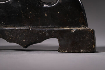 Closeup shot of an antique black Chinese calligraphy pen holder on a gray background