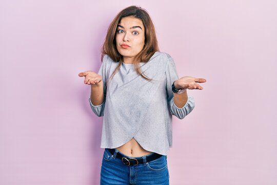 Young caucasian girl wearing casual clothes clueless and confused expression with arms and hands raised. doubt concept.