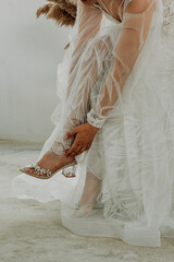 Bride dresses shoes before the wedding ceremony. bride morning. Closeup detail of bride putting on...