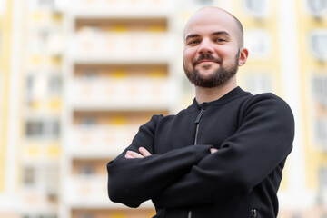 Close-up of a cheerful pleased attractive man with a beard, has a wide smile, rejoices in success at work. Free space for your text