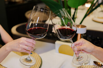 Young Woman Hand Toasting Red Wine Glasses at Restaurant