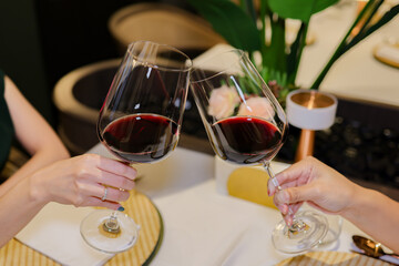 Young Woman Hand Toasting Red Wine Glasses at Restaurant