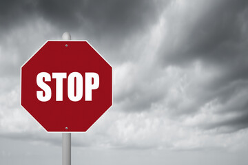 Red stop sign with stormy background.