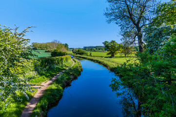 A view from a bridge down the Grand Union Canal at Wistow near to Market Harborough, UK in summertime