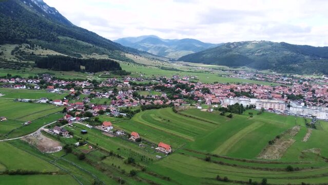 High and wide overhead shot of small Romanian town, a village close to mountains
