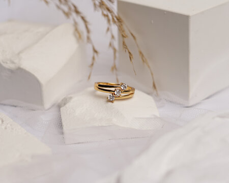 Wedding ring set on white stone. The jewelry ring is ready to be showcased and sold. The wedding ring is a sign of the love of the couple. Pearls and diamonds complete the ring's beauty. focus blur.