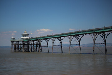 Fototapeta premium Clevedon pier putside of Bristol in South West England under the scorching sun on a clear summers day as the river servern lazily flows by